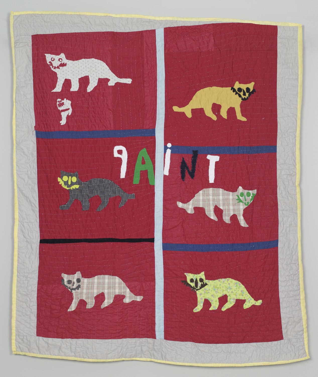 Image of a quilt with cats against red background and the word paint appliqued in the middle.