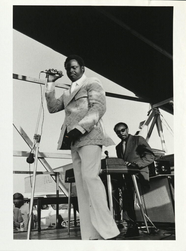Performer Ernie K-Doe, with pianist Tommy Ridgley, circa 1974, New Orleans Jazz & Heritage Festival, photographer: Robin von Breton Davis, Robert Palmer collection HJA-027, Box 268, 219.8570, Tulane University Special Collections.
