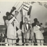 L. to r.: Bill Matthews, trombone; Albert Burbank, clarinet; and Wallace Davenport, trumpet, perform during Jazz Fest’s Steamboat Stomp evening concert on the Steamer President riverboat, April 18, 1974, photographer: Jerry Bray, Mina Lea Crais collection HJA-060, 117.106, Tulane University Special Collections.