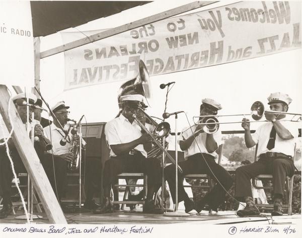 Onward Brass Band performs at Jazz Fest, l. to r.: Louis Cottrell, clarinet; Oscar Rouzan, alto saxophone; Waldren “Frog” Joseph, trombone; unidentified sousaphone player (possibly Jerry Greene); Freddie Lonzo, trombone; and Wendell Eugene, trombone; 1976, photographer: Harriet Blum, Hogan Archive Photography Collection, PH003076, Tulane University Special Collections.