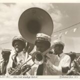 Doc Paulin’s Band performs at Jazz Fest, l. to r.: unidentified tenor saxophonist; Dwayne Paulin, sousaphone; Darryl Walker, trombone; Doc Paulin, trumpet; Michael White, clarinet; and Ricky Paulin, snare drum; 1977, photographer: Harriet Blum, Hogan Archive Photography Collection, PH003243, Tulane University Special Collections.