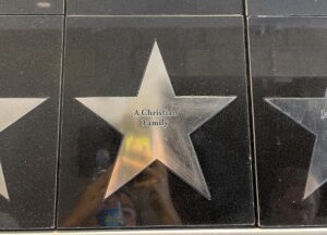 Silver star plaque on outside wall that reads "A Christian Family"