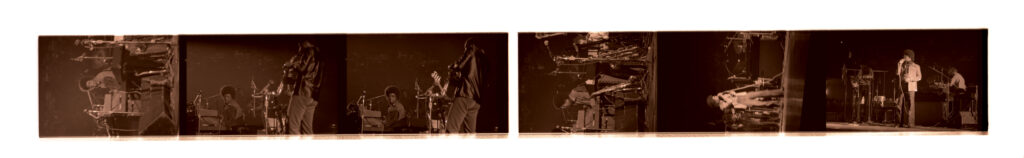 Negative strip of Herbie Hancock, keyboards, performing with his band, the Headhunters (pictured: Bennie Maupin, saxophone, clarinet; Mike Clark, drums; Bill Summers, percussion) at the Jazz Fest night concert on Friday, April 19, 1974, Municipal Auditorium, photographer unidentified, Tad Jones collection HJA-056, Box 28, Tulane University Special Collections.