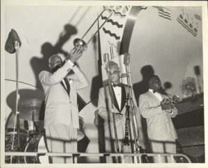 L. to r.: Bill Matthews, trombone; Albert Burbank, clarinet; and Wallace Davenport, trumpet, perform during Jazz Fest’s Steamboat Stomp evening concert on the Steamer President riverboat, April 18, 1974, photographer: Jerry Bray, Mina Lea Crais collection HJA-060, 117.106, Tulane University Special Collections.