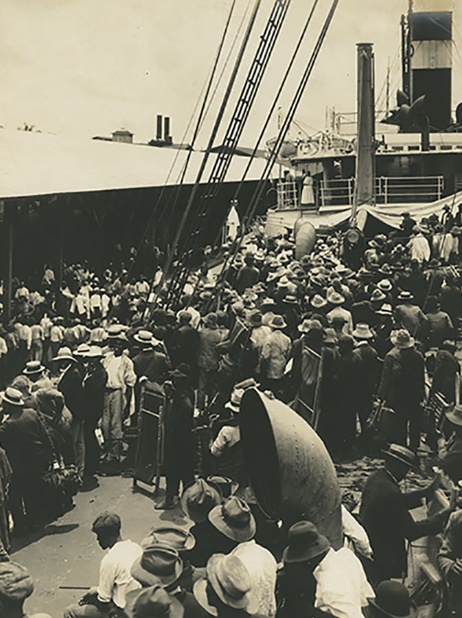 ADockedShipWithPeopleCrowdedOnTheDeck